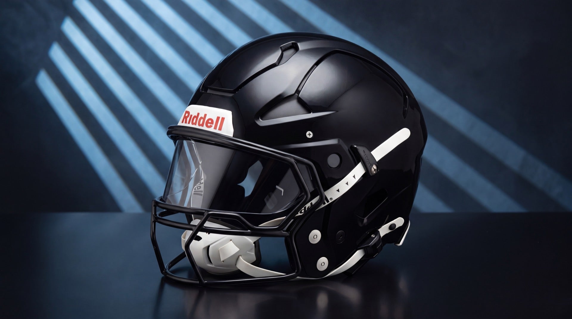 Gloss black Riddell Axiom helmet with its integrated panoramic facemask and built-in eye shield in cold blue striped studio light